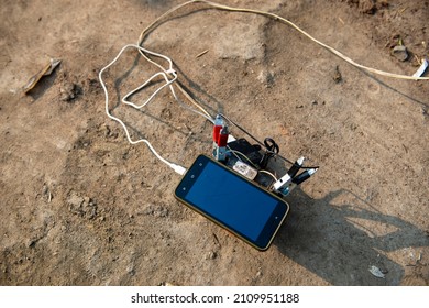 New Delhi, India- Jan 01 2022: A battery placed on muddy ground to charge a mobile phone. 