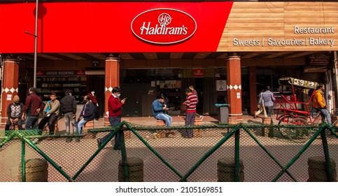 New Delhi, India- Jan 10 2022: People Eating Snacks Outside Haldiram Outlet In Chandni Chowk, Old Delhi. Haldiram In An Indian Sweets, Snacks And Restaurant Company.