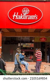 New Delhi, India- Jan 10 2022: People Eating Snacks Outside Haldiram Outlet In Chandni Chowk, Old Delhi. Haldiram In An Indian Sweets, Snacks And Restaurant Company.