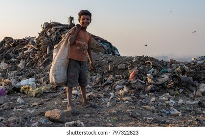 New Delhi, India - January 19, 2018: A young poor Indian boy collection waste plastic bottles in his sack to earn his livelihood.