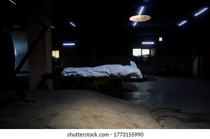 NEW DELHI, INDIA - July 10, 2020: COVID 19 Death In Indian. Relatives And Health Workers Unload The Body Of A Man Who Died From The Coronavirus Disease (Covid 19) For His Cremation At Crematorium.