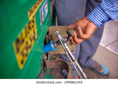 New Delhi, India- June 11 2021: An employee Handle Gas dispenser for refuel Vehicle fueling facility,  refuels a vehicle with CNG gas station in New Delhi,