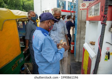 New Delhi, India- June 11 2021: Pump attendant counting received money from customers after filling cng gas in auto rickshaw compressed natural gas, CNG pump station in New Delhi,