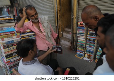 New Delhi, India - June 14, 2019 - Shopkeepers Use A Smartphone To Watch The ICC Cricket World Cup Match Between India And Pakistan, In New Delhi.