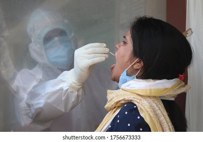 New Delhi, India, June 15, 2020, A Lab Technician Wearing PPE Kit While Collecting Swab Sample From A Woman For COVID-19 Test, At A Medical Lab During Ongoing COVID-19 Lockdown.