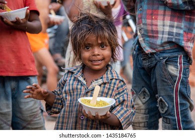 New Delhi, India - June 23, 2019: A young poor boy with his bowl of food in the capital city of India. 20% of the population or 220 million people in India are below poverty line