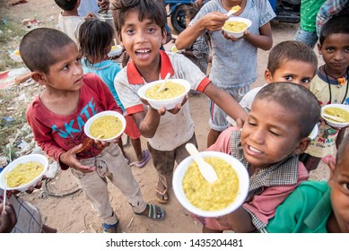 New Delhi, India - June 23, 2019: A group of young poor children with their bowl of food in the capital city of India. 20% of the population or 220 million people in India are below poverty line