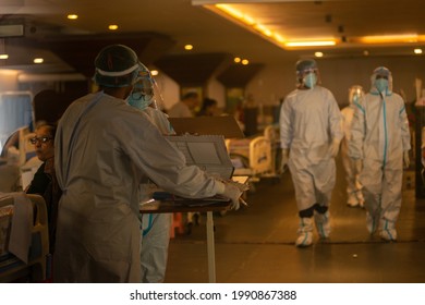 New Delhi, India- June 7 2021: A Healthcare Worker Wearing A Personal Protective Equipment (PPE) Attends To Covid-19 Patients Inside A Banquet Hall Temporarily Converted To A Covid19 Care Centre 