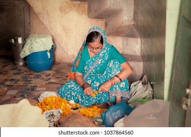 New Delhi, India - June 8th, 2013: A Aged Woman Making Marigold Garland Inside Famous Chandni Chowk Area. 