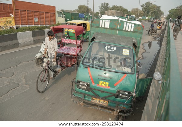 NEW DELHI, INDIA - MARCH 12: Unidentified Indian\
driver sleeps in the cabin of his truck on a bridge in Delhi, India\
on March 12, 2014. New Delhi is the busiest city in Asia with\
unregulated traffic.
