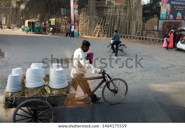NEW DELHI, INDIA - MARCH 18 : Indian and foreign\
people worker bike bicycle and use tricycle carrying and delivery\
product on the road of rural at Delhi city on March 18, 2019 in New\
Delhi, India