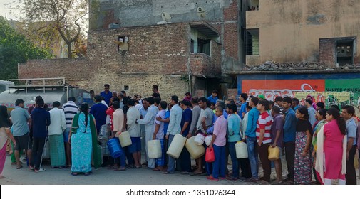New Delhi, India - March 27 2019: People queue for taking water from Delhi Jal board tanker in the early morning. This shows the water scarcity around the densely populated societies.