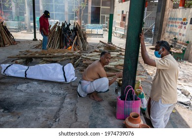 New Delhi, India, May 13 2021: Relatives Of A Covid-19  Victim Perform The Last Rites During A Cremation, A View Of Ghazipur Cremation Ground, Priest And South Indian Man Doing Last Rite.