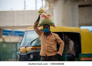 New Delhi, India, May 31 2021:Migrant Labour Carrying Sack Of Grain On His Head Returning To Delhi After Lockdown, Walking Roadside Near Anand Vihar Bus Terminal New Delhi Searching Transportation