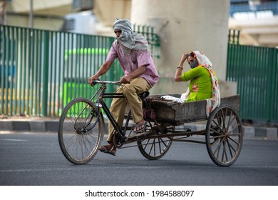 New Delhi, India, May 31 2021: Man With His Wife Commuting On Goods Loading Tricycle Rickshaw Near Anand Vihar Bus Terminal Going To Vegetable Market