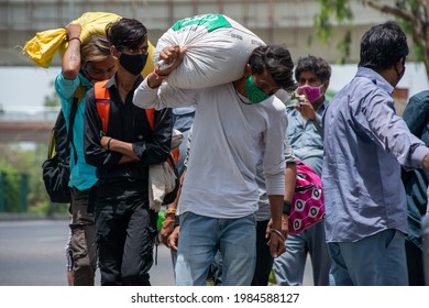 New Delhi, India, May 31 2021: Migrant Labour Carrying Sack Of Grain On His Shoulder Returning To Delhi After Lockdown, Walking Roadside Near Anand Vihar Bus Terminal New Delhi; 