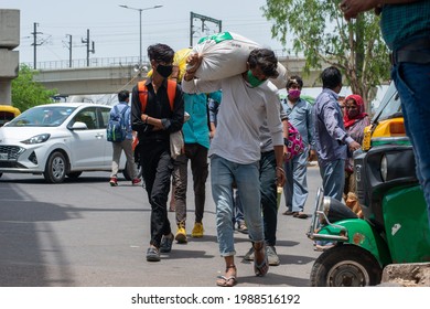 New Delhi, India, May 31 2021: Migrant Labour Carrying Sack Of Grain On His Shoulder Returning To Delhi After Lockdown, Walking Roadside Near Anand Vihar Bus Terminal New Delhi; 