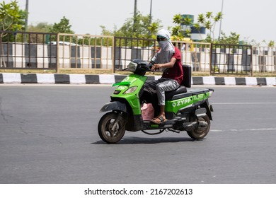 New Delhi, India- May 9 2022: Food Delivery Boy Using Electric Bike For Delivery. Local Food Delivery Boy Using Ev Scooty For Parsal Delivery In Delhi