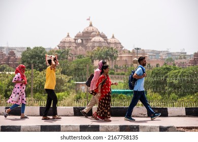 New Delhi, India- May 9 2022: Group Of People Walking On Road During Heat Wave In Delhi. Tourist On Road 