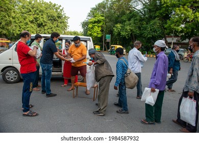 New Delhi, India, May31 2021: Group Of Indian People With Face Mask, Falling In Line For Some Food Along A Public Road, Distributing Food Packets And Masks To The Daily Wagers And Homeless People.