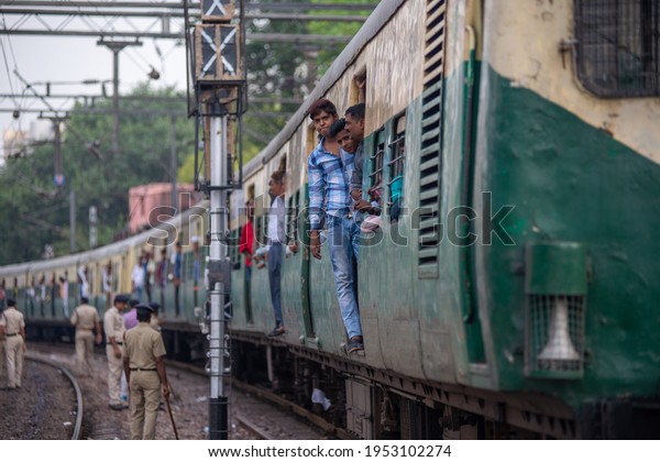 New Delhi, India-  September 7 2018: electric\
multiple unit or EMU Passenger train Moving on track while GRP\
security personal on track.