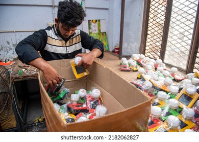 New Delhi, India-23 May 2022: Indian Worker Carrying Box Of Solar Lights, Solar Light Manufacturing Factory In Delhi, Solar Powered Light Manufacturing Factory.