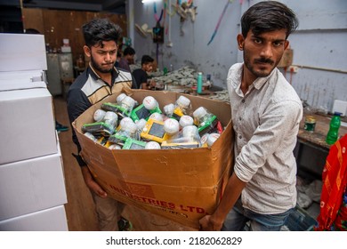 New Delhi, India-23 May 2022: Indian Worker Carrying Box Of Solar Lights, Solar Light Manufacturing Factory In Delhi, Solar Powered Light Manufacturing Factory.