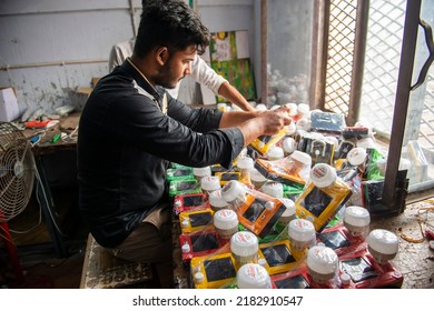 New Delhi, India-23 May 2022: Indian Worker Carrying Box Of Solar Lights, Solar Light Manufacturing Factory In Delhi, Solar Powered Light Manufacturing Factory.