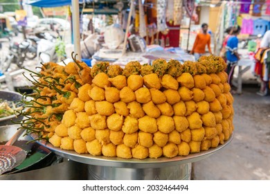 New Delhi, India-Aug 24 2021: Closeup Of A Street Food Vendor Selling Popular Indian Takeout Food Pakoras, Selling Verity Of Pakora Like Ram Ladoo, Onion, Spinach, Plantain, Chili. Stack Of Pakora