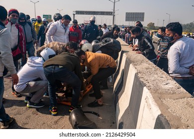 New Delhi, India-Feb 20 2022: Car And Motorcycle Accident At Delhi Meerut Expressway Due To Overspeeding. Bike Rider Hit By A Overspeed Car. People Helping To Road Accident Victims