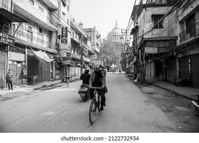 New Delhi, India-Jan 16 2022: A Cyclist On Deserted Road Towards Jama Masjid During The Weekend Curfew Imposed By The Delhi Government In Wake Of Rising Covid-19 Cases