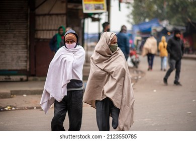 New Delhi, India-Jan 16 2022: A Migrant Laborer Wraps A Quilt Walking On Road During An Ongoing Weekend Curfew Imposed To Curb The Spread Of The Covid-19 Coronavirus Infections