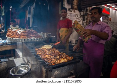 New Delhi, India-Jan 28 2022: Spicy roasted tandoori butter chicken, prepared for sale at aslam chicken during evening as street food in Old Delhi market. It is famous for spicy Indian non vegetarian