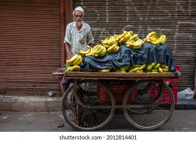 New Delhi, India-July 22 2021: Muslim Street fruit vendor selling Bananas on Hand cart,  Choori Walan Rd, Sita Ram Bazar, Chandni Chowk, matia mahal market near jama masjid in old delhi.