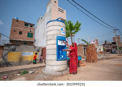 New Delhi, India-March 25, 2014: Woman Filling Water Cane Using Pre Paid Card At Sarvajal Drinking Water ATM At Jhuggi Jhopri Colony, New Delhi, The Water ATMs Operated By A Pre Paid Card .