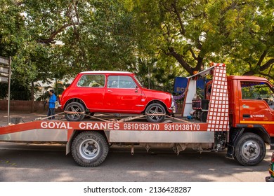 New Delhi, India-March 6 2022: Logistic Vehicle Carrying Antique Vintage Mini Coper Car On Road 