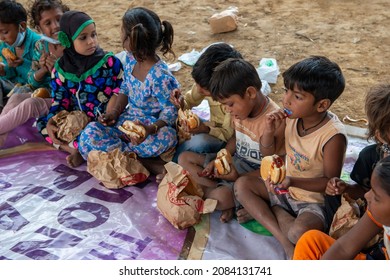 New Delhi, India-Nov 3 2021: Group of Slum children sitting at charitable School eating Burger during celebration of school opening after long covid lockdown.