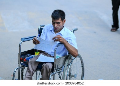 New Delhi, India-Sep 1 2019: Disabled Student Sitting On Wheelchair Filling Admission Form At The Indira Gandhi National Open University (IGNOU), Central Open Learning University Located In Delhi