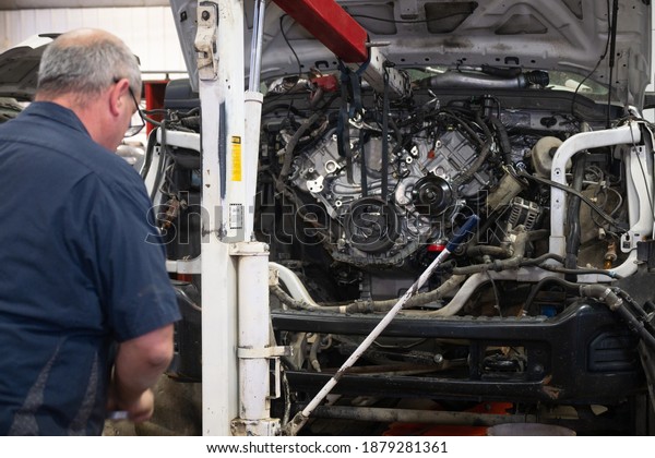 A New Diesel Engine Being Pushed Into The Engine\
Bay Of A Truck