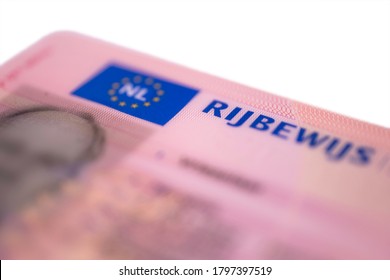 New Dutch pink driver's license in credit card format isolated on white background. Focus on on the first letters of the word RIJBEWIJS (drivers licence)