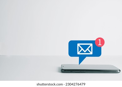 New Email ,massage,unread email concept.,Smartphone with new e-mail or notification icon on white table over white background with copyspace use for technology idea.