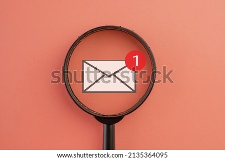 New email,message,unread email,nontification concept.,View through a magnifying glass on 1 new email alert icon over pink pastel background.