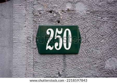 new enameled house number two hundred and fifty. White lettering on a green background