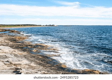 New England coastline with waves crashing on rocky beach on a sunny day.   - Powered by Shutterstock