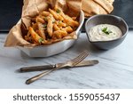 New England fried clam strips served with a bowl of tartar dipping sauce