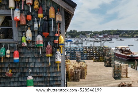 New England Lobster Fishing Dock:  Marker buoys for lobster traps decorate the side of a fishing shack on a wharf in Maine.
