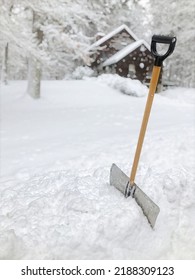 New England Winter Snow Shovel Planted In Snow Bank In Front Of Old Colonial On The Hill