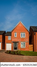 New English Red Brick Build Home In A Residential Development In Central England, UK. Detached Traditional House With Black Door And Garage.