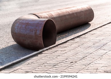 A New Fitting Pipe Turn Lies On The Pavement Waiting For The Repair Of The Main Pipe, Backlight And Selective Focus