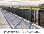 New footbridge with metal railings and a view of windmills